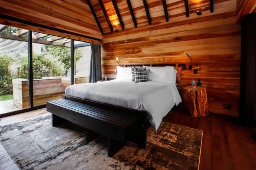 a bedroom with a bed and a large window at Ort Hotel in Campos do Jordão