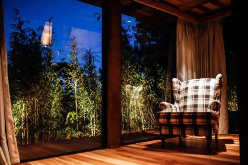 a chair sitting on a porch with a window at Ort Hotel in Campos do Jordão