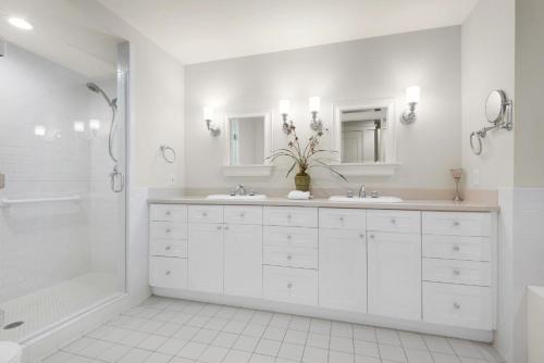 a white bathroom with two sinks and a bath tub at Watercolor Townhouse 9 in Seagrove Beach