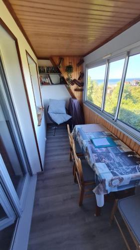 - une table à manger dans une petite maison avec fenêtres dans l'établissement Appartement en bord de mer, à Villers-sur-Mer