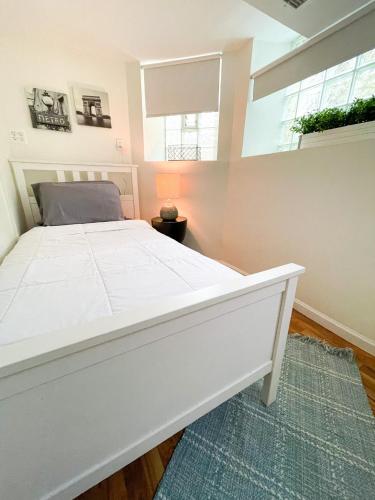 a white bed in a room with a window at Wrigley Garden Unit in Chicago
