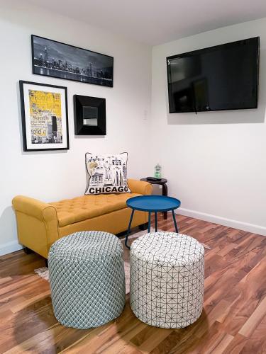 a living room with a yellow couch and two stools at Wrigley Garden Unit in Chicago