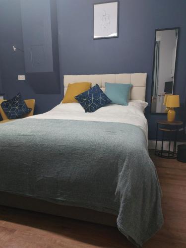 1 dormitorio con 1 cama grande y paredes azules en spacious self-contained accommodation 135 cantebury road, en Kent