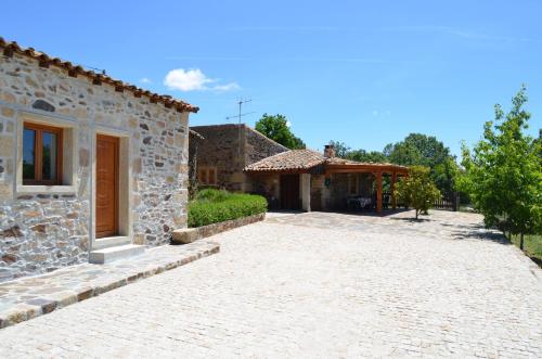a stone house with a driveway in front of it at Casa do Manego in Quadrazais