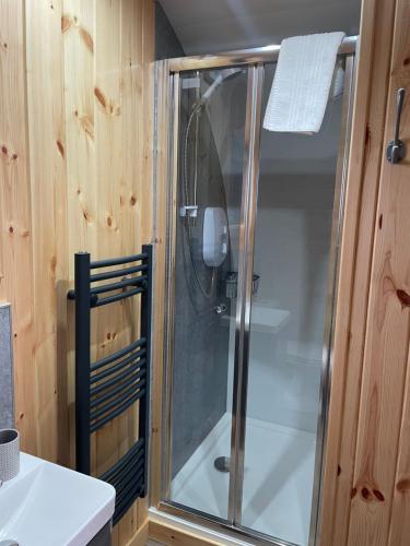 a shower with a glass door in a bathroom at Allt Yelkie Pod Aon, Earlish in Earlish