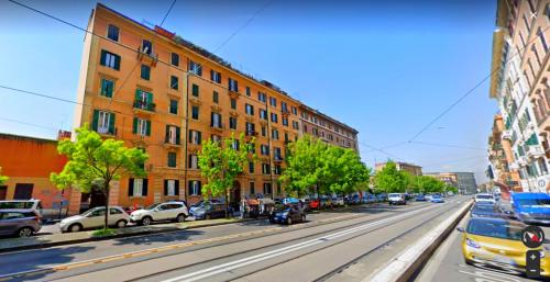 Una calle de la ciudad con coches aparcados en la calle. en Vacanze Romane Colosseo apartment, en Roma