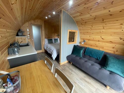 a room with a couch and a bed in a cabin at Allt Yelkie Pod Aon, Earlish in Earlish