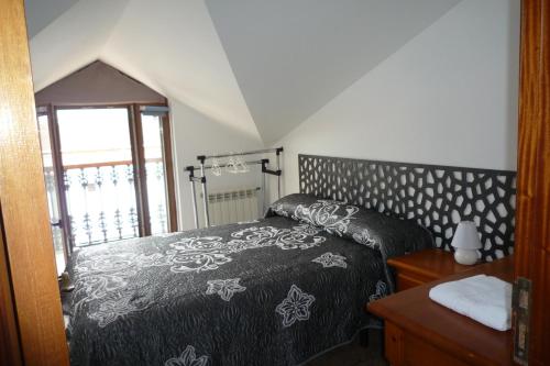 1 dormitorio con 1 cama con colcha en blanco y negro en LOS ATICOS, en Santander