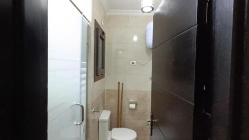 a small bathroom with a toilet and a shower at صيف في جراند هيلز الساحل الشمالي in Al Ḩammām