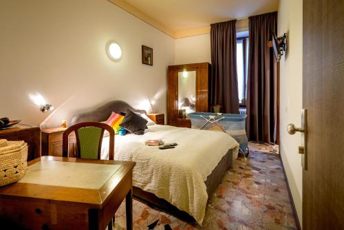 een slaapkamer met een bed, een bureau en een tafel bij B&B Ca Tunin in Tirano