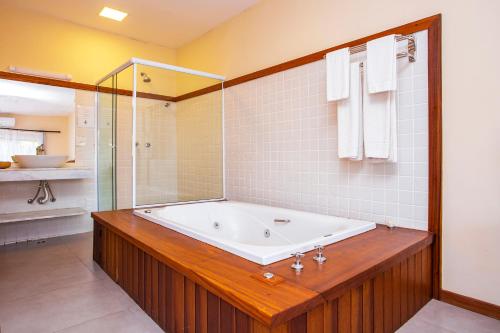 a large bathroom with a tub and a shower at Pousada Altamira in Ilhabela