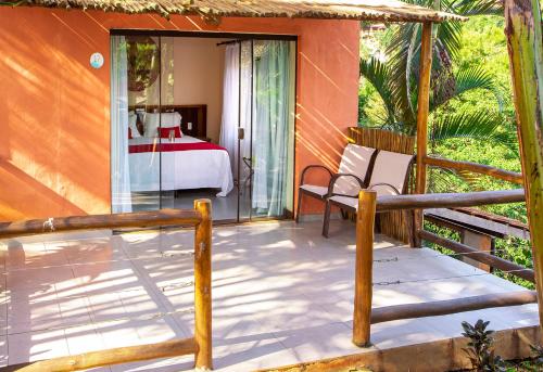 a porch of a house with a bed and a bedroom at Pousada Altamira in Ilhabela