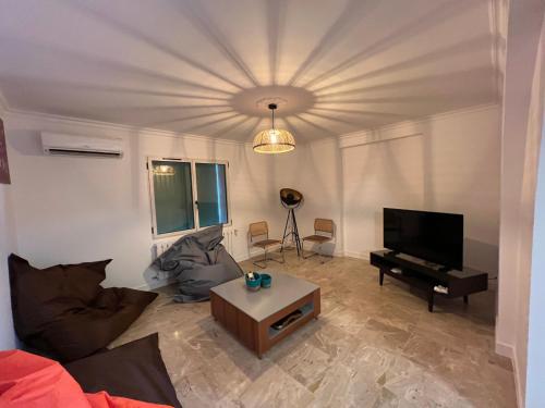 a living room with a couch and a flat screen tv at Mas Grenadine, magnifique villa du Piémont Cévenol in Sauve