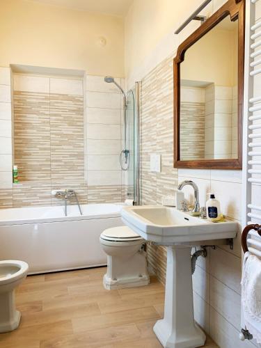 a bathroom with a sink and a tub and a toilet at Villa Delbia - Il Sogno in Candelo