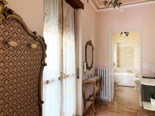 y baño con ducha, aseo y espejo. en Villa Delbia - Il Sogno, en Candelo