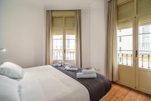 a bedroom with a large bed with towels on it at Minimal Rooms by ELE Apartments in Málaga