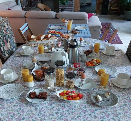 una mesa de desayuno con alimentos y bebidas para el desayuno. en Domaine du Carouge, en Lirey