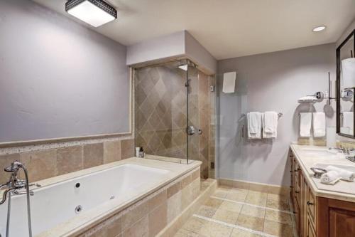 uma grande casa de banho com banheira e chuveiro em Vail Arrabelle 4 Bedroom Residence em Vail