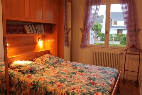 - une chambre avec un lit doté d'un couvre-lit floral et d'une fenêtre dans l'établissement Grande maison vue sur mer, à Équeurdreville-Hainneville