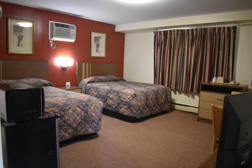 a hotel room with two beds and a television at South Hills Motel in Pittsburgh
