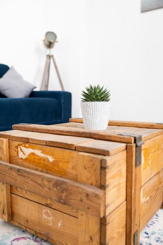 a wooden coffee table with a potted plant on top at Apartments am Neuen Theater - Altstadt - Zentral - Küche - Wifi - Powered by Ko-Living in Halle an der Saale