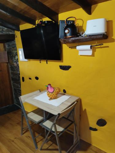 a small table in a room with a yellow wall at Montanhas do Xisto - Casa do Portal in Lousã