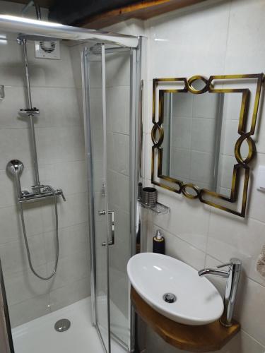 Un baño con ducha, lavabo y espejo. en Montanhas do Xisto - Casa do Portal, en Lousã