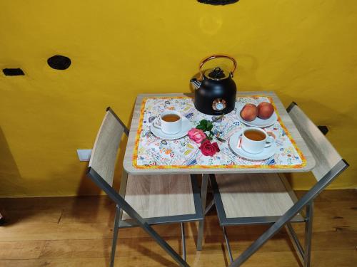 una mesa con 2 sillas y un hervidor de agua. en Montanhas do Xisto - Casa do Portal, en Lousã