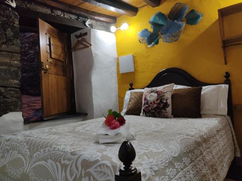 ein Schlafzimmer mit einem Bett mit Blumen darauf in der Unterkunft Montanhas do Xisto - Casa do Portal in Lousã