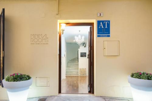 una entrada a un edificio con dos macetas en Minimal Rooms by ELE Apartments, en Málaga