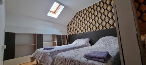 a bedroom with two twin beds with white blankets at Sobe Royal Apartman in Šabac