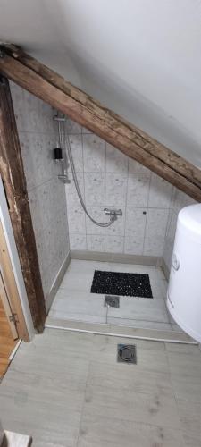 a bathroom with a shower with a tile floor at Sobe Royal Apartman in Šabac
