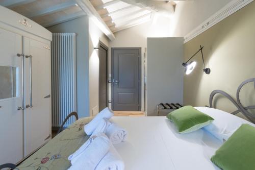 a bedroom with a white bed with green and white pillows at Anima di Vinci in Vinci