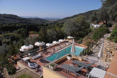 a view of a pool with umbrellas and chairs at Villa Denise in Campiglia Marittima