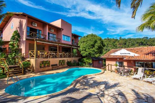 an exterior view of a house with a swimming pool at Pousada Altamira in Ilhabela
