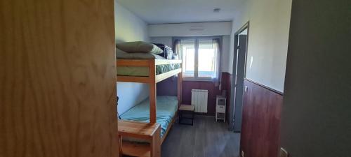 Cette chambre comprend 2 lits superposés et une fenêtre. dans l'établissement Appartement en bord de mer, à Villers-sur-Mer