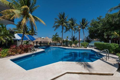 a swimming pool at a resort with palm trees at Hotel Imperial Laguna Faranda Cancún in Cancún
