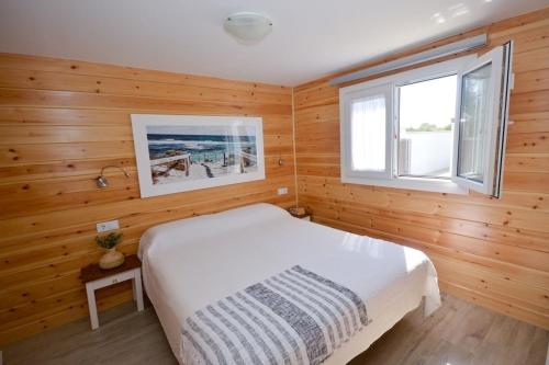 1 dormitorio con cama blanca y ventana en Casa Nordica cerca del mar en El Palmar