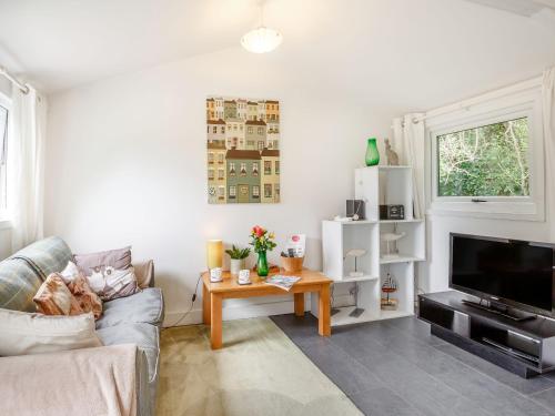 a living room with a couch and a table at The Shepherd's Hut in Aberdyfi