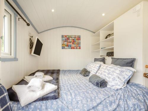 a bedroom with a bed with towels on it at The Shepherd's Hut in Aberdyfi