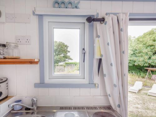 a kitchen with a sink and a window at The Shepherd's Hut in Aberdyfi