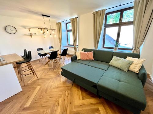 a living room with a green couch and a table at Apartmán Elen in Nové Město nad Metují