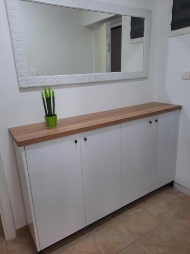 a white dressing table with a mirror on a wall at Apartman NK in Nikšić