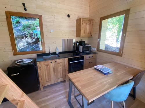 - une cuisine avec une table en bois dans une cabine dans l'établissement Chalet l'Empreinte, à Saint-Étienne-de-Tinée