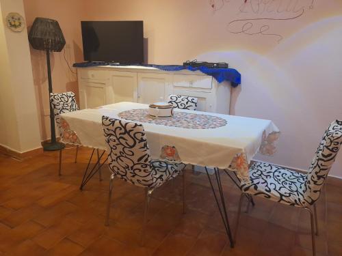 a table and chairs with a table and a tv at SOGNO Vacanze in Massa