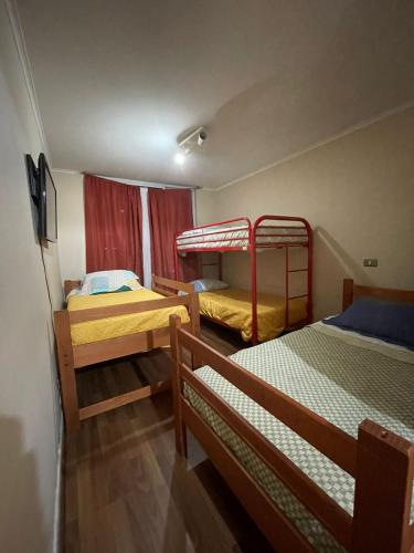 a room with two bunk beds and a tv at Orella 6p Apartament in Antofagasta