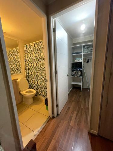 a bathroom with a toilet and a closet at Orella 6p Apartament in Antofagasta