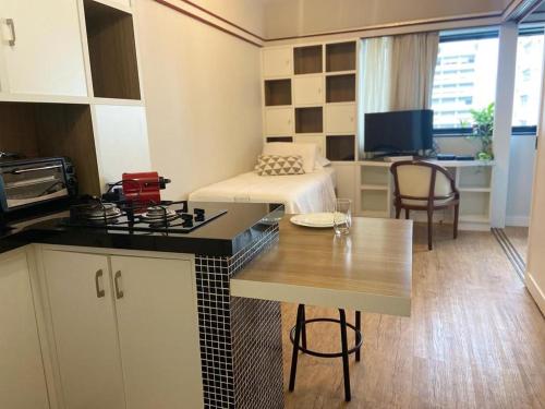 圣保罗JP Crauford Choice Suites的一间带一张床的房间和一间带桌子的厨房
