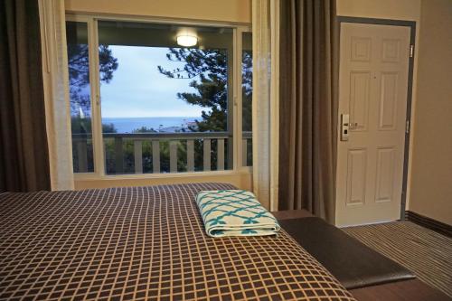 a bedroom with a bed and a large window at Crescent Bay Inn in Laguna Beach