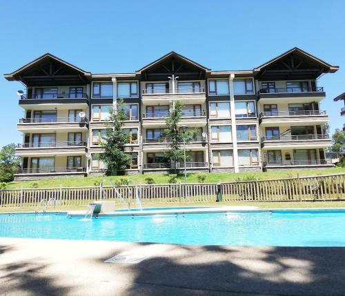 a large building with a swimming pool in front of it at Pucon villarrica in Pucón